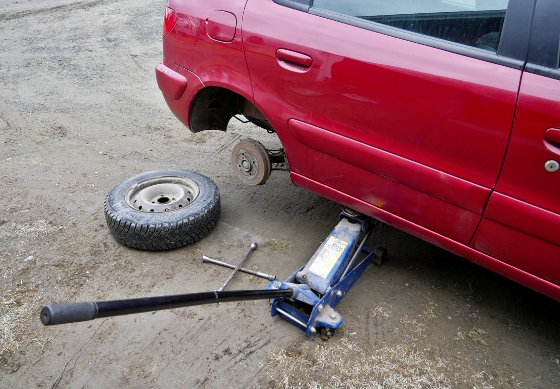 Changing a flat tire with a jack on level ground
